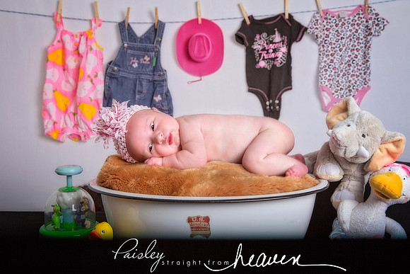 Portrait of newborn girl in vintage tub
